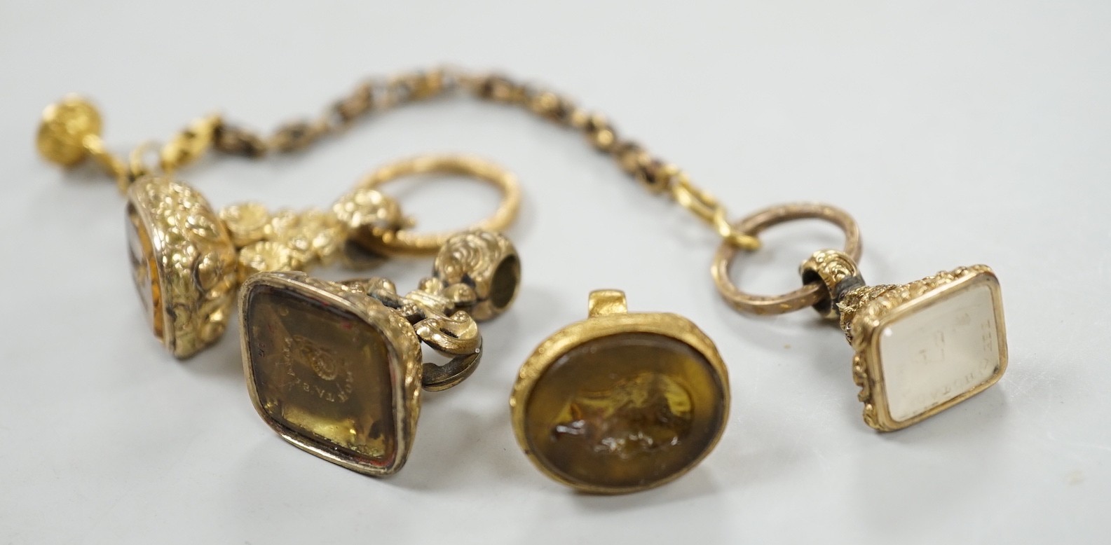 Four assorted 19th century gold plated fob seals, set with citrine, glass or carnelian, largest 30mm.